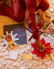 Graf Lantz | Merino Wool 10 Poinsettia Trivet - Red, shown protecting a table surface, highlighting its functional and festive design with a holiday meal setting.