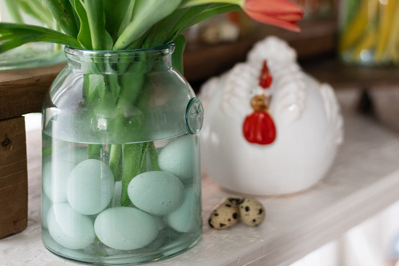 French Bee Mason Jar Small featured as a vase with eggs and a red flower, showcasing its elegant, vintage-inspired design suitable for kitchen decor.