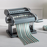 Marcato | Atlas 150 Pasta Maker (Ice) with pasta dough being rolled and cut, highlighting its manual functionality for homemade Italian pasta.