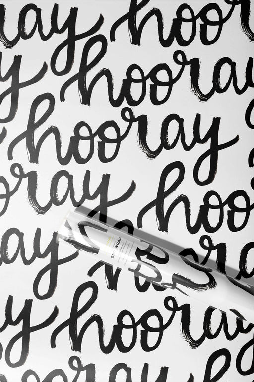The Paper Curator | Gift Wrap - Merry features elegant black calligraphy on white satin paper, sized at 20 x 29, perfect for any occasion.
