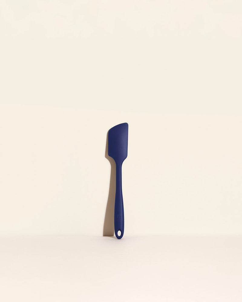 GIR | Skinny Spatula - Navy, showcased on a white surface, highlighting its sleek design and durable, antimicrobial unibody ideal for versatile kitchen use.
