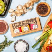 Spicewalla | Grill & Roast Gift Collections, Grill & Roast 3 Pack with rubs, surrounded by fresh ingredients, ideal for enhancing grilled and roasted dishes.