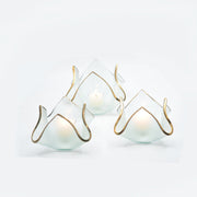 Annie Glass | 7 x 7 x 5 XL Handkerchief Votive, featuring frosted-glass with a gold-trimmed, petal-like shape, beautifully illuminated by lit tealight candles.