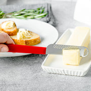 Microplane Butter Blade shaving butter curls onto a dish; slices of bread with curls and rosemary nearby, illustrating its efficient design for easy spreading.
