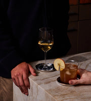 Holcomb Studio Puddle Coasters, Set of Four displayed with a glass of wine, showcasing their elegant and functional design for protecting surfaces from condensation.