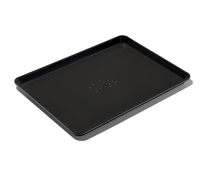 Great Jones | Holy Sheet - Pepper: Close-up of the nonstick ceramic-coated half-sized sheet pan, ideal for easy cleanup and stylish table presentation.