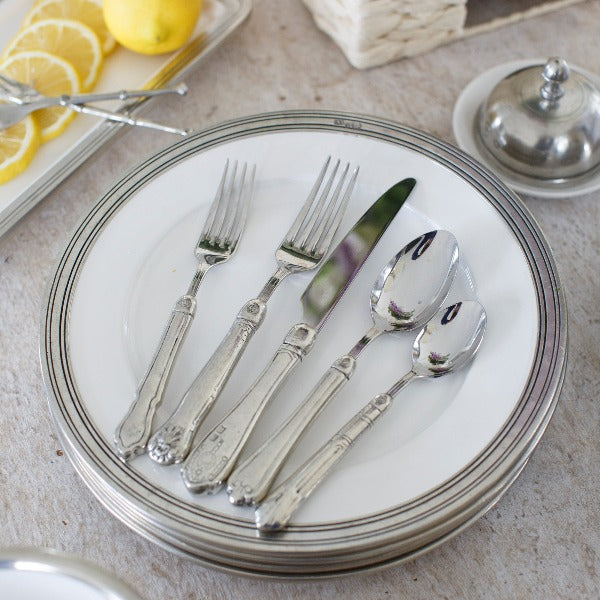 Arte Italica & Crown Linen Designs Hotel 5-Piece Placesetting with vintage-style silver flatware on white-rimmed plates, showcasing Italian craftsmanship and subtle pattern variations.