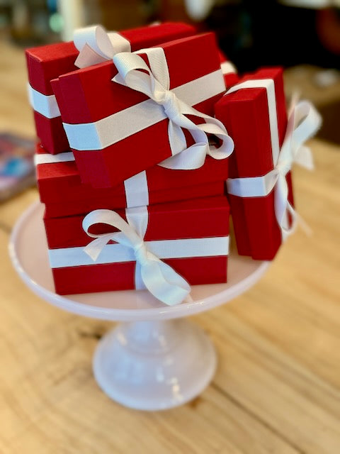 Condor | Valentine Truffle Box: A stack of red gift boxes with white ribbons, filled with assorted handcrafted truffles perfect for savoring or gifting.