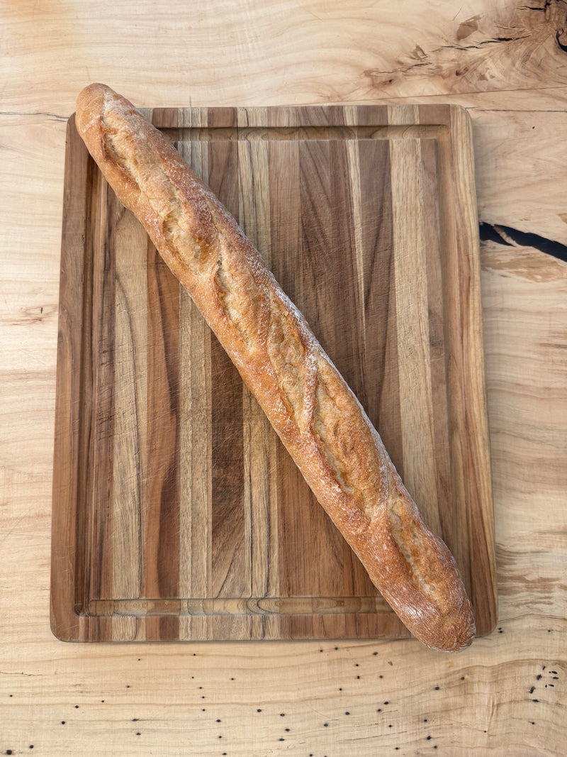 Independent Baking Co. | Daily Fresh Baked Bread - Classic Baguette on a wooden board, showcasing its crusty texture, perfect for home baking with professional results.
