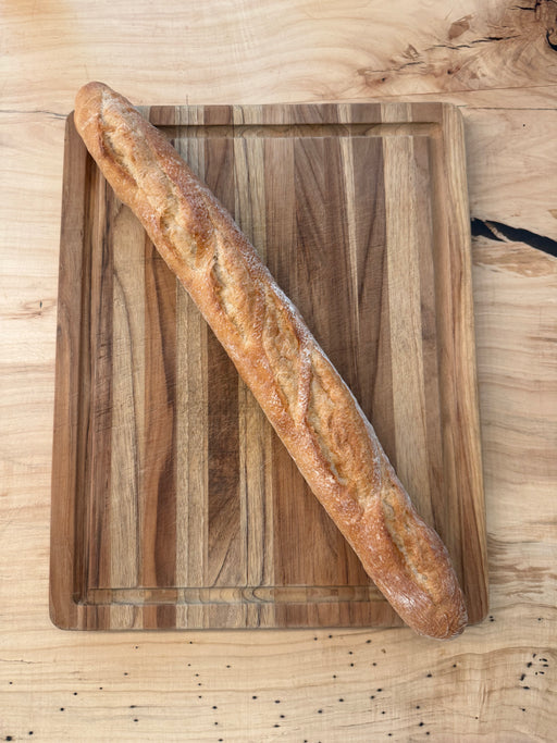 Independent Baking Co. | Daily Fresh Baked Bread - Classic Baguette on a wooden board, showcasing its crusty texture, perfect for home baking with professional results.