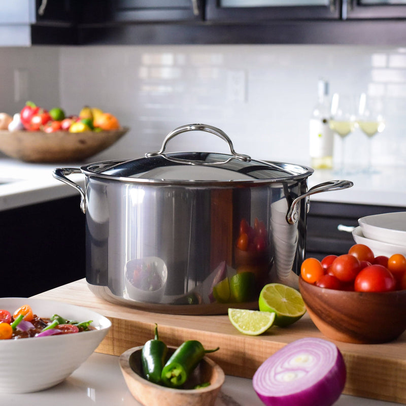 Hestan | NanoBond Cookware, 8qt Stockpot + Lid on a wooden board with fresh ingredients, showcasing its durable, high-capacity design for perfect culinary creations.
