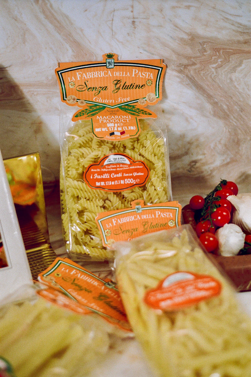 La Fabbrica della Pasta | Gluten Free Fusilli Corti in clear bags, with cherry tomatoes and garlic, embodies authentic Italian gluten-free pasta craftsmanship.