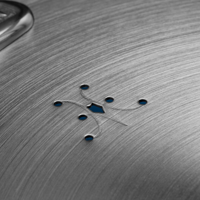 Hestan | Commercial Clad Stainless Steel Universal Lid, 12.5 Inches, showing steam vent holes around a central cutout with a polished handle visible.