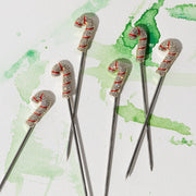 Joanna Buchanan | Cocktail Picks - Candy Cane: Set of six festive cocktail picks with candy cane designs, perfect for holiday drinks and appetizers, enhancing any festive gathering.
