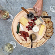 J.K. Adams | Maple Round Cheese Board with Cracker Groove, elegantly showcasing cheeses, meats, bread, and condiments, perfect for entertaining with style.