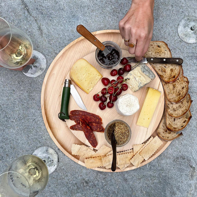 J.K. Adams | Maple Round Cheese Board with Cracker Groove, elegantly showcasing cheeses, meats, bread, and condiments, perfect for entertaining with style.