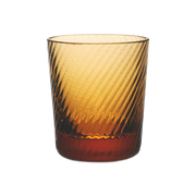 Match | Lando Shot Glass, Amber, Twist: A cylindrical amber-tinted tumbler with a diagonal wave-like texture, creating a swirling light-and-shadow effect.