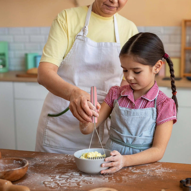 Woman using Lamson | Vintage Mini Avocado + Spud Masher in a kitchen, demonstrating its compact design and efficiency for mashing in small bowls.