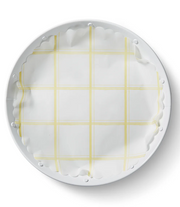 Lemon Chiffon Original Flat Plate Liners feature a yellow plaid pattern on compostable paper, ideal for enhancing table settings at Athens Cooks kitchen store.