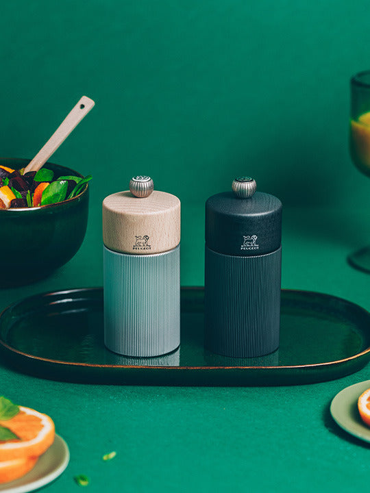 Peugeot | Line Pepper Mill Aluminum + Beechwood, Natural, 4.75 Inches, on a tray, highlighting its ribbed aluminum body and adjustable grind knob with Peugeot logo.