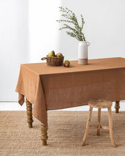MagicLinen forest green linen tablecloth, 59 x 98 inches, showcasing a simple seam finish ideal for diverse dining settings, available at Athens Cooks.