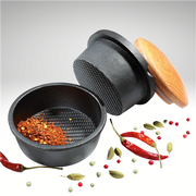 Frieling XL Spice Buddy, a black cast iron pot with a beech wood lid, featuring red peppers and spices, ideal for enhancing your kitchenware collection.