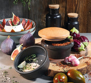 Frieling XL Spice Buddy Cast Iron with Beech Wood Lid, displayed among assorted foods, highlighting its role in enhancing culinary experiences.
