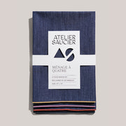 Atelier Saucier | Rainbow Denim Napkins, Set of 4, featuring dark-denim fabric with colorful piped edges, wrapped in a branded band, adding flair to dining.
