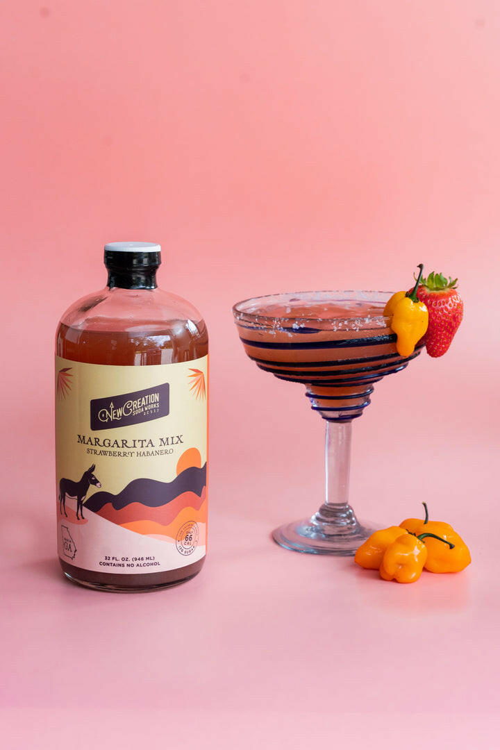 New Creation Soda Works | Margarita Mixes - Strawberry Habanero, featuring strawberries and a label, highlighting a sweet, spicy flavor for cocktails or mocktails.