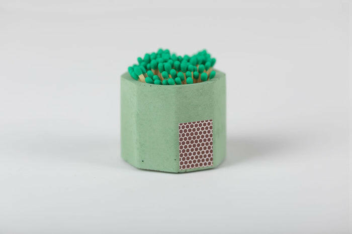 Tenn Prairie | Match Holders with Striker + Matches: Close-up of a blue concrete match holder with cork bottom, containing 70 green-tipped matches and a side striker pad.