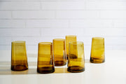 Moroccan Cone Glassware Large Amber - Set of 6: Hand-blown cone-shaped glasses with visible bubbles, made from recycled bottles, ideal for drinks or as vases.