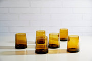 Moroccan Cone Glassware Small - Amber - Set of 6, features hand-blown, cone-shaped glasses with visible bubbles, crafted from recycled glass, ideal for beverages or decorative use.