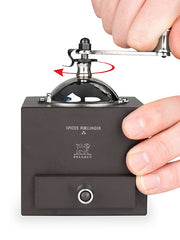 Peugeot | Roellinger Pepper Mill, Chocolate: A hand-crank spice grinder with a stainless steel dome and drawer base, designed for precise grinding.