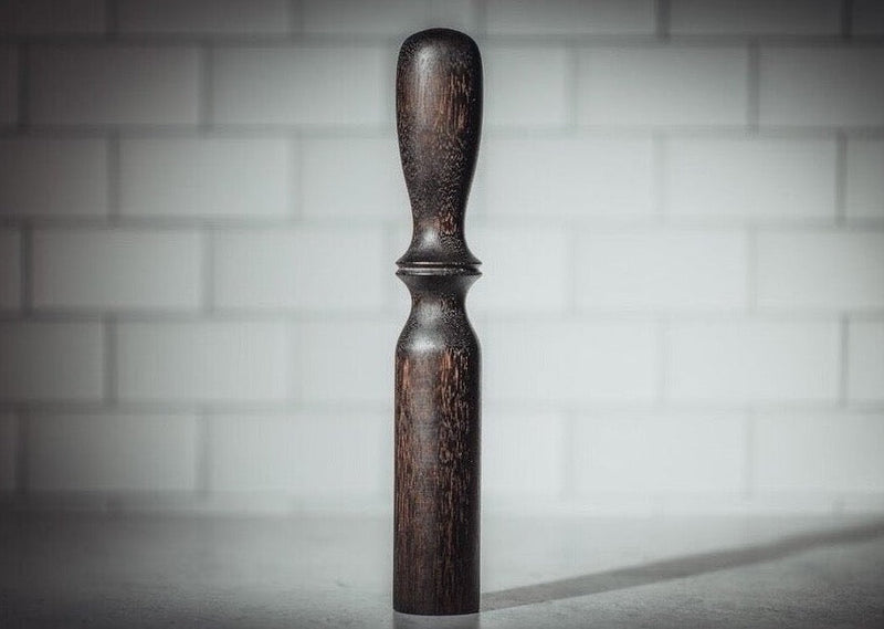 Blanc Creatives cocktail muddler in Noir dark wood finish against white tile background