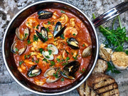 Hestan NanoBond Cookware, 3.5qt Essential Pan + Lid, filled with seafood pasta, showcasing its wide base and ergonomic handle on a stone countertop.