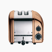 Dualit | 2 Slice Classic Toaster, Copper, featuring polished metal body, rotary controls, and lever, ideal for toasting with precision and style.