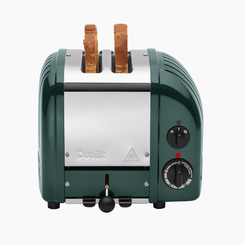 Dualit | 2 Slice Classic Toaster, Evergreen, with two slices toasting, featuring browning control, lever, and power indicator, handmade with ProHeat® elements for versatile toasting.