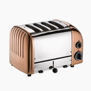 Dualit | 4 Slice Classic Toaster, Copper, with four bread slots, front lever, and side knobs for browning and functions like defrost. Stainless steel with copper-tone panels.