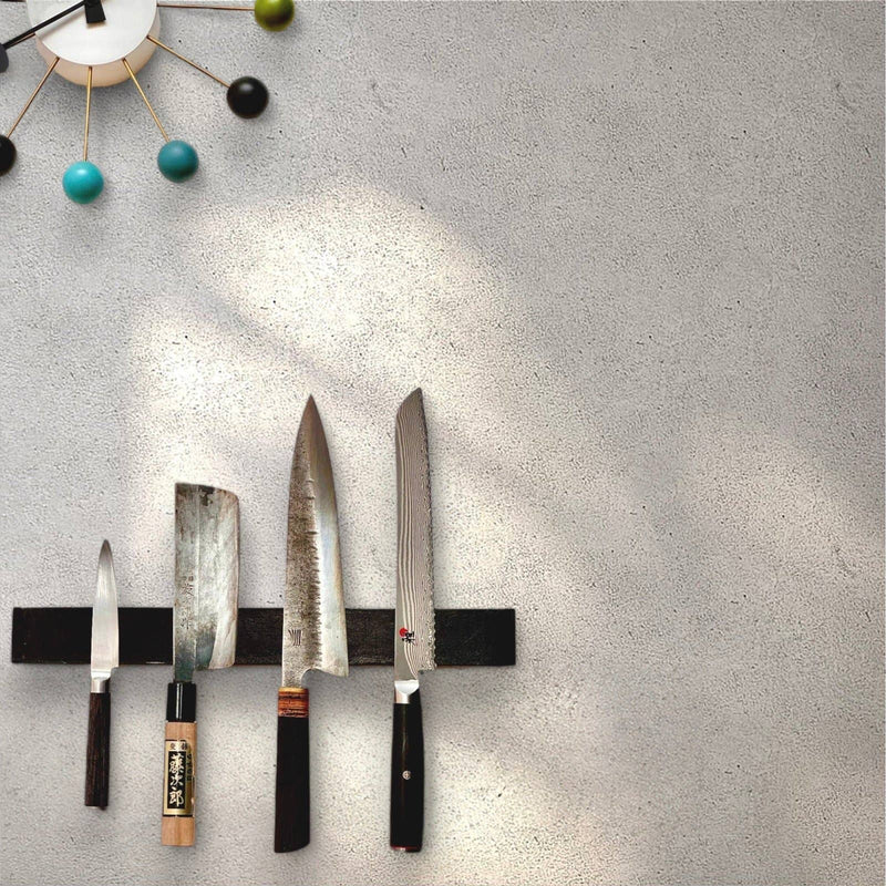 Rune-Jakobsen Design 'Leather protected' knife magnet in oak with light brown Italian leather, showcasing multiple knives securely held on a kitchen wall.