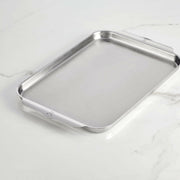 Hestan Provisions | OvenBond Tri-Ply Bakeware - Medium Rack Only, showcasing a durable stainless-steel baking sheet with low sides and curved handles on a light countertop.