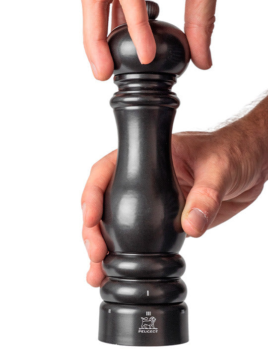 Peugeot | Paris u'Select Pepper Mill, Satin Black, being adjusted for grind size. Features adjustable settings and sustainably sourced wood.