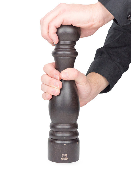 Peugeot | Paris u'Select Wood Pepper Mill Chocolate, 12 inches, shown in use with hands demonstrating its ergonomic design and grinding adjustment system.