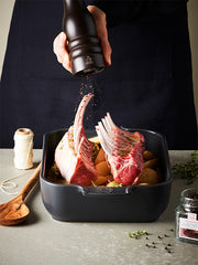 Peugeot | Paris u'Select Wood Pepper Mill Chocolate, 12 inches, held over lamb racks, grinding pepper onto herbs and potatoes in a roasting tin.