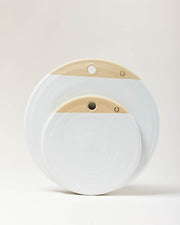 Farmhouse Pottery | Cheese Stone (14-Inch) showcases two nested, round serving boards with natural clay tops and white glazed bottoms, perfect for cheese or charcuterie.