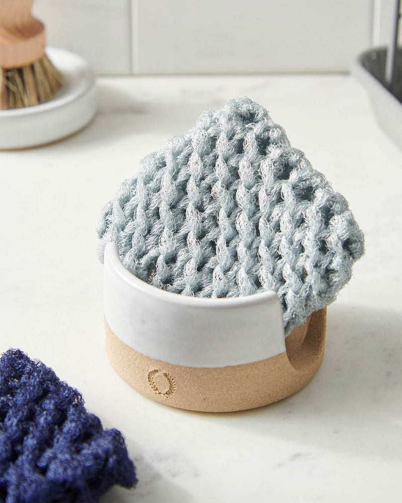 Farmhouse Pottery | Sponge Holder displaying a two-tone ceramic crock with a hand-knit scrub pad, accompanied by a second pad and wood-handled brush, highlighting eco-friendly kitchen essentials.