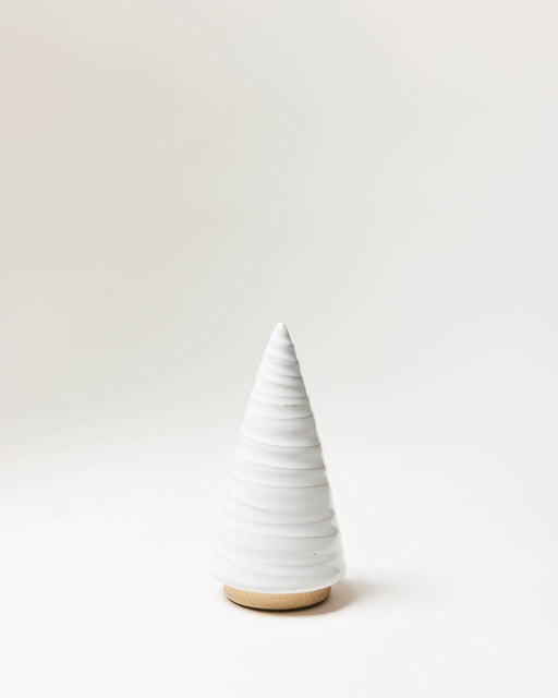Farmhouse Pottery | Spruce Woodland Trees - Small: A ribbed, ceramic cone with a pointed top, set on a cork base, embodying minimalist design.