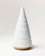 Farmhouse Pottery | Spruce Woodland Trees - Large: A minimalist, white glazed ceramic cone with horizontal coils, on a wood-toned base, ideal as a decorative accent.