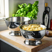 Hestan Provisions | Stainless Steel Colanders - 3 Quart shown straining fusilli pasta on a wooden board, highlighting its polished finish and ergonomic design.