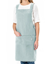 MagicLinen Pinafore Cross-Back Linen Apron in Dusty Blue, features criss-cross straps and side pockets, ideal for cooking or gardening.