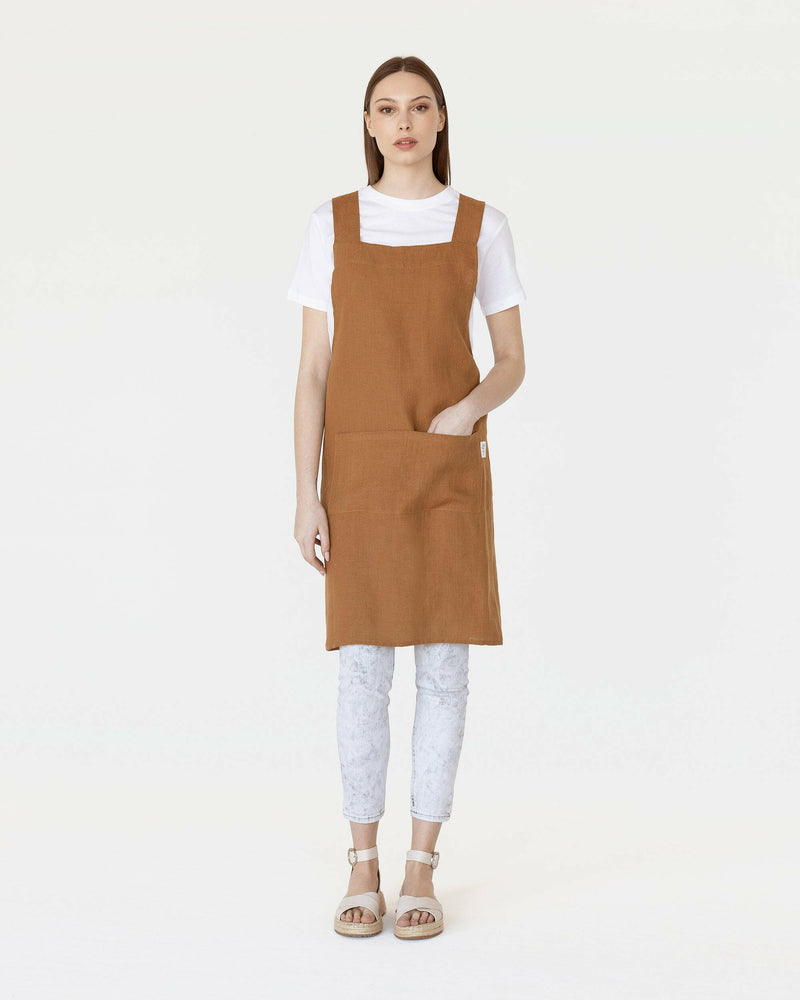 MagicLinen Pinafore Cross-Back Linen Apron in Dusty Blue, featuring criss-cross straps and side pockets, ideal for cooking or gardening enthusiasts.